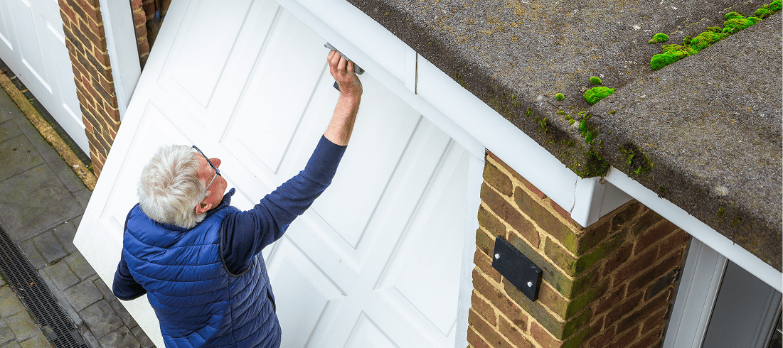 Man opening a garage door, viewed overhead.