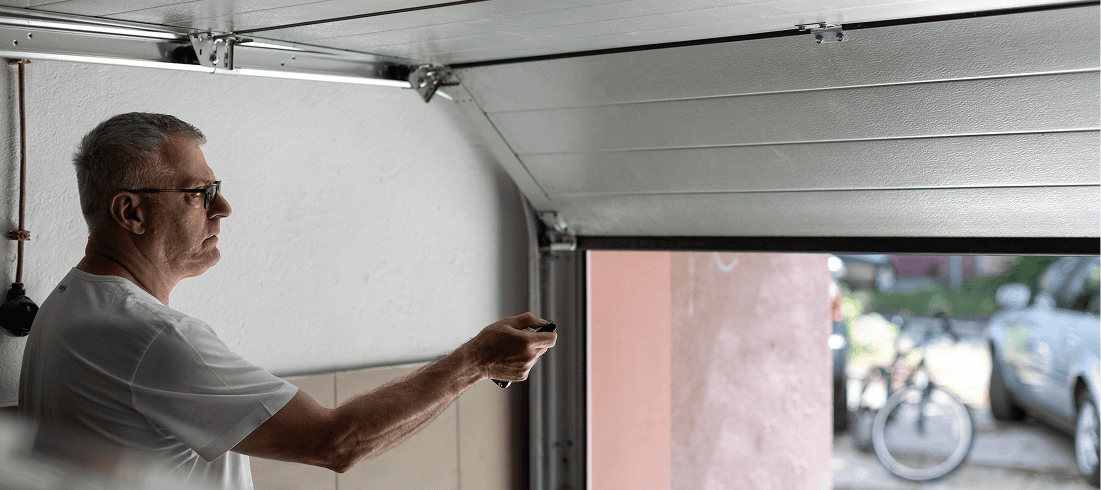 Man using remote to open garage door.